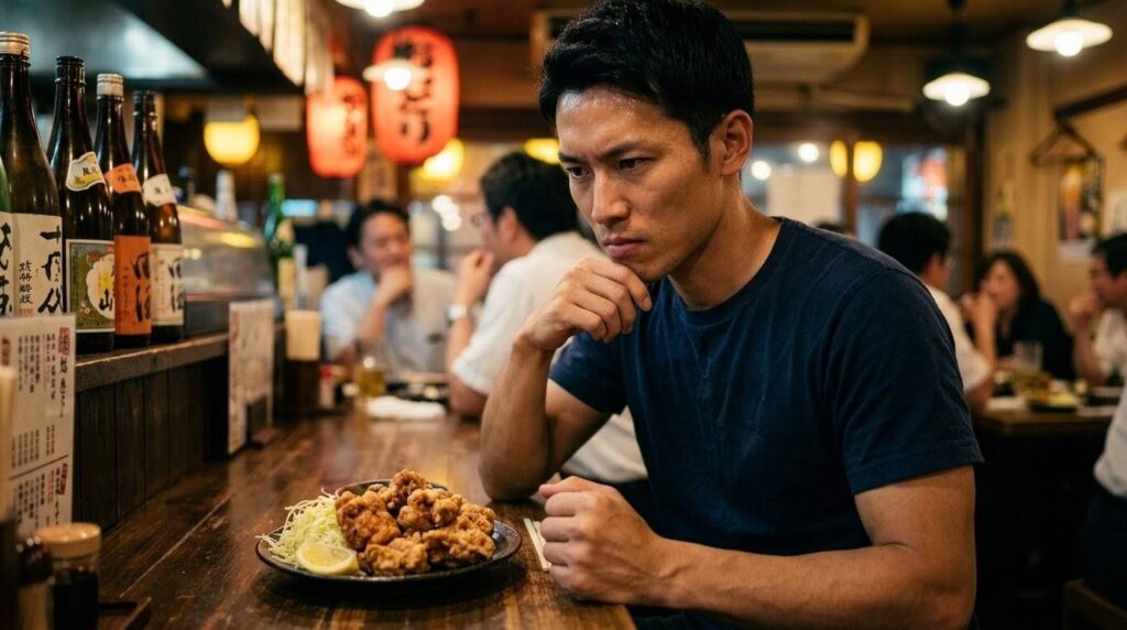 目の前の唐揚げの誘惑に耐える決意の表情をした日本人トレーニー