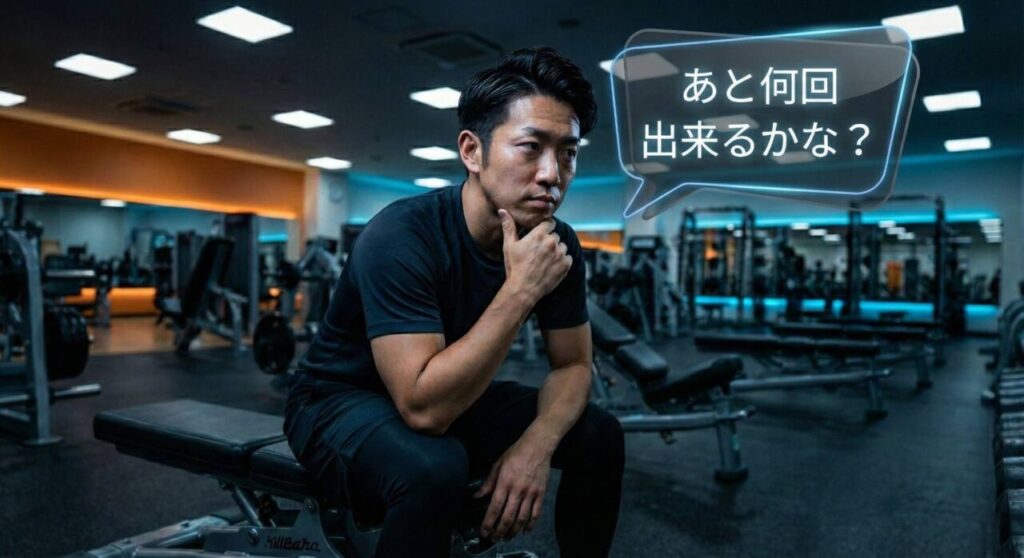 ジムで、ベンチに座り顎に手を当てて真剣な表情で考えている男性の写真。半透明で近未来的なデザインの吹き出しの中に「あと何回出来るかな?」という文字が浮かんでおり、トレーニング中に自分の限界やRIR(あと何回反復できるか)を冷静に見極めようとしている様子を表現している。